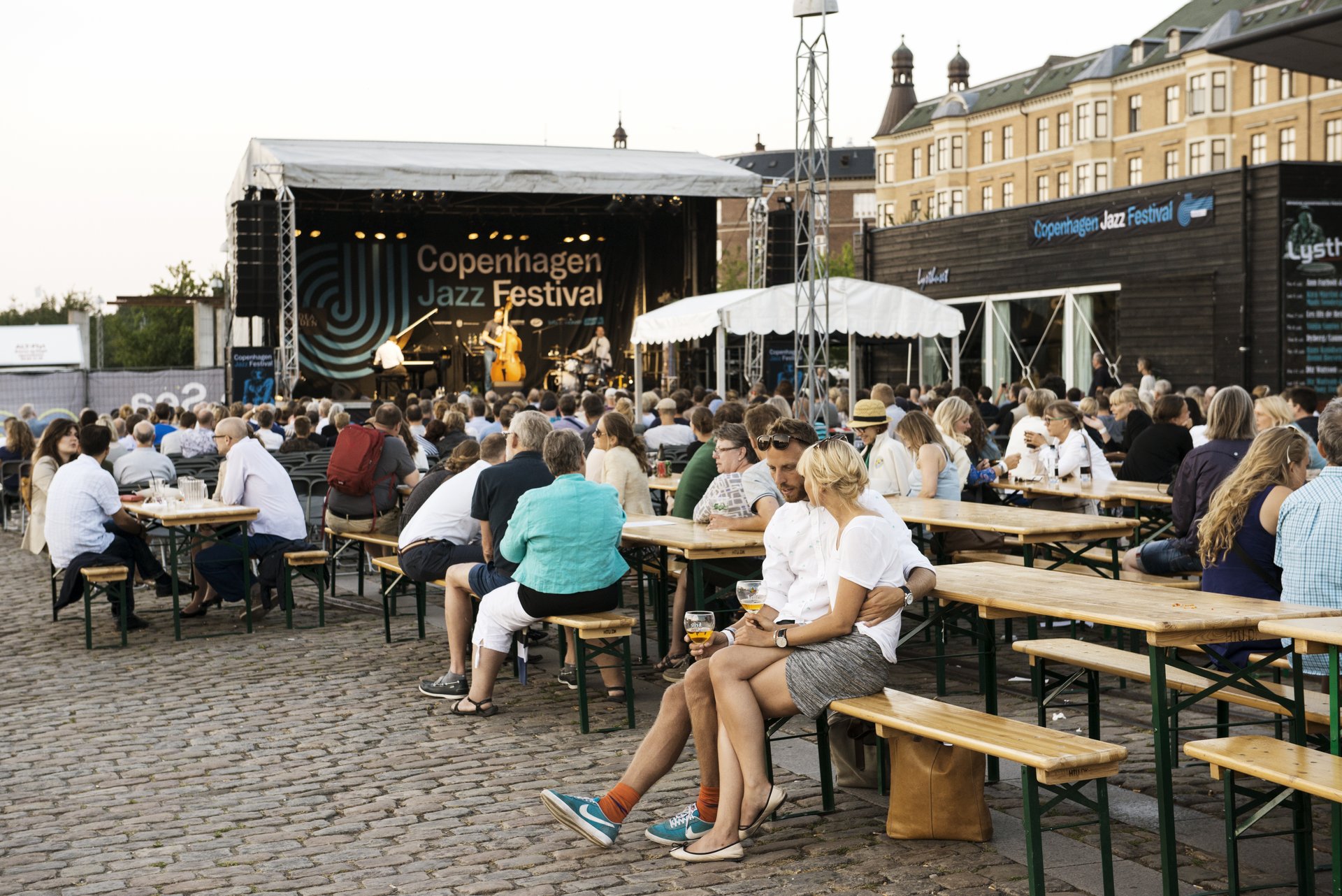 En gruppe personer nyder musikken ved et udendørs arrangement