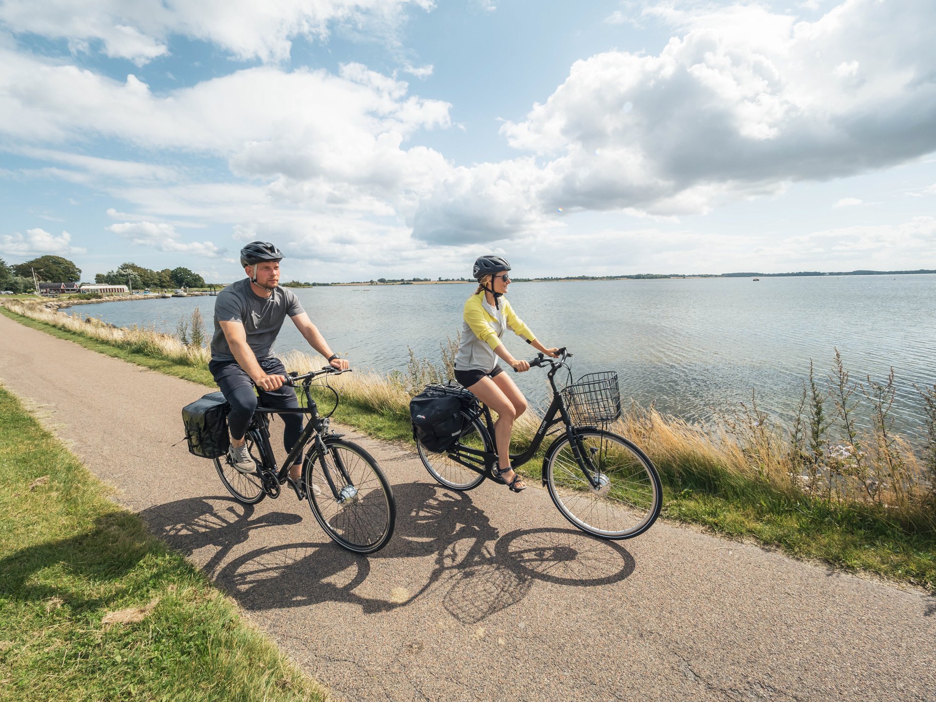 To personer cykler på elcykler 